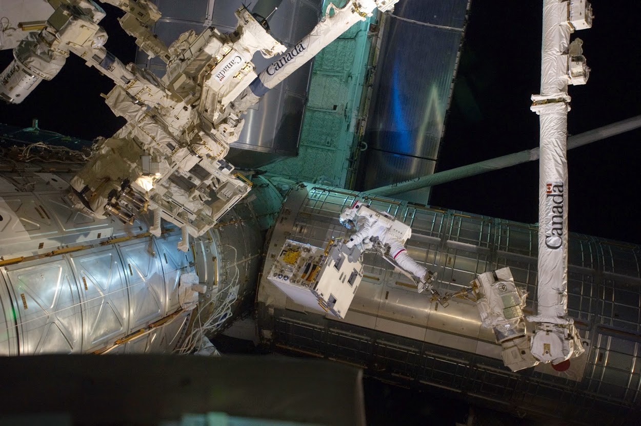 En 2011 pendant une EVA, Ron Garan transfert un module de pompe dans la soute de la navette Atlantis