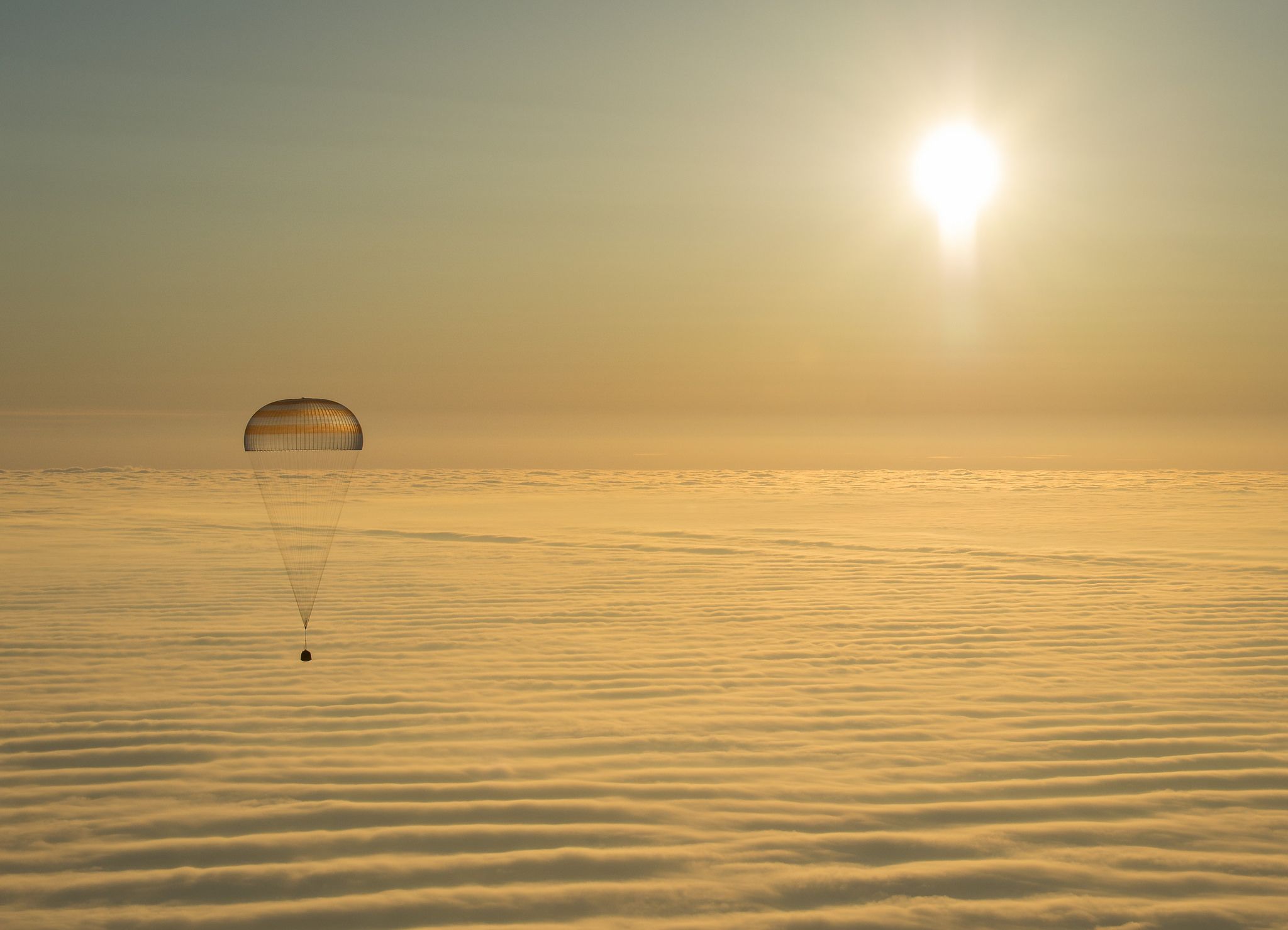 Retour Expedition 42 capsule Soyouz sous parachute au dessus des nuages. Crédits : NASA/B. Ingalls