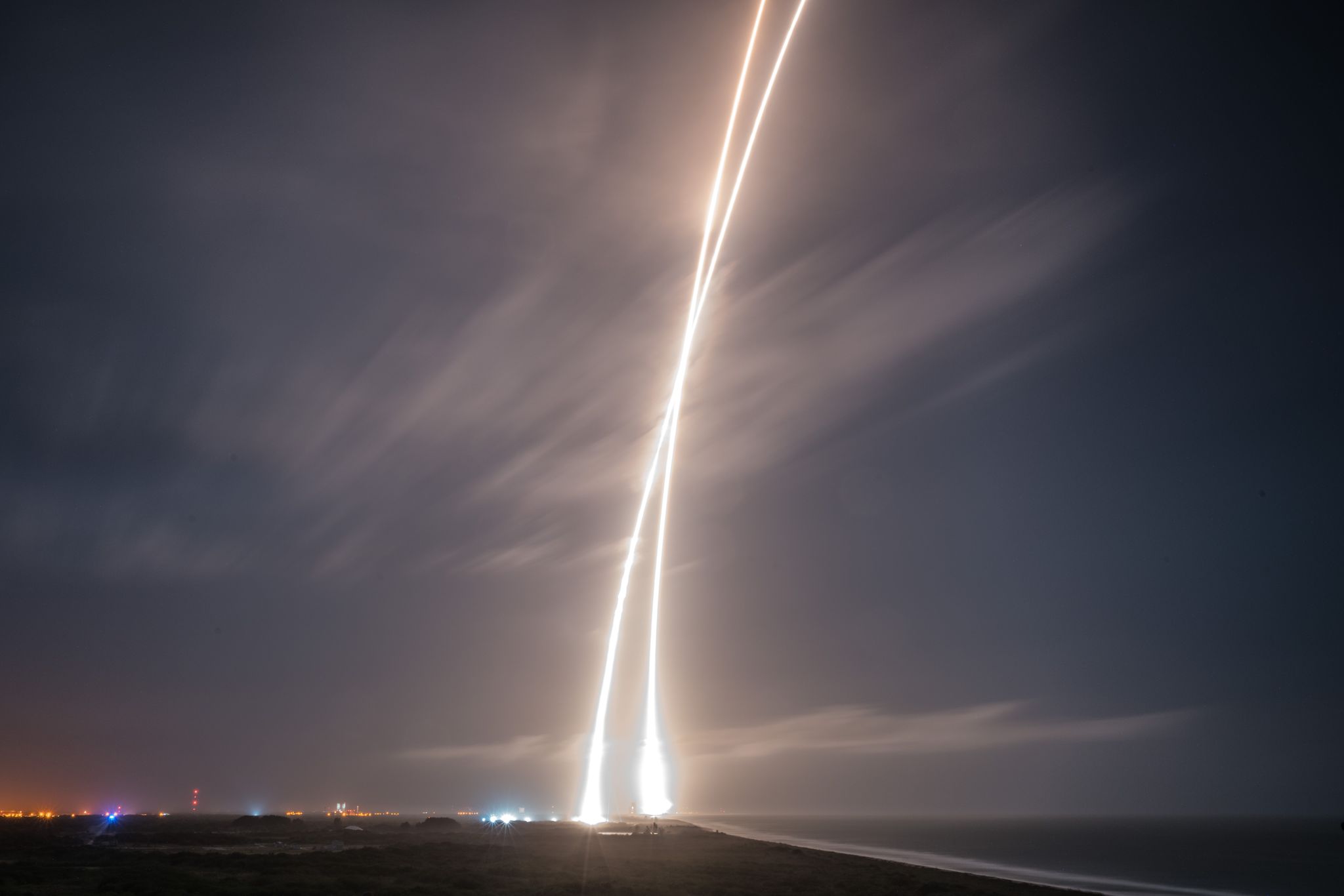 Cap Canaveral, le 21 Décembre 2015, décollage de la fusée Falcon 9 (à droite) et atterrissage de son premier étage (à gauche) (Crédits : SpaceX)