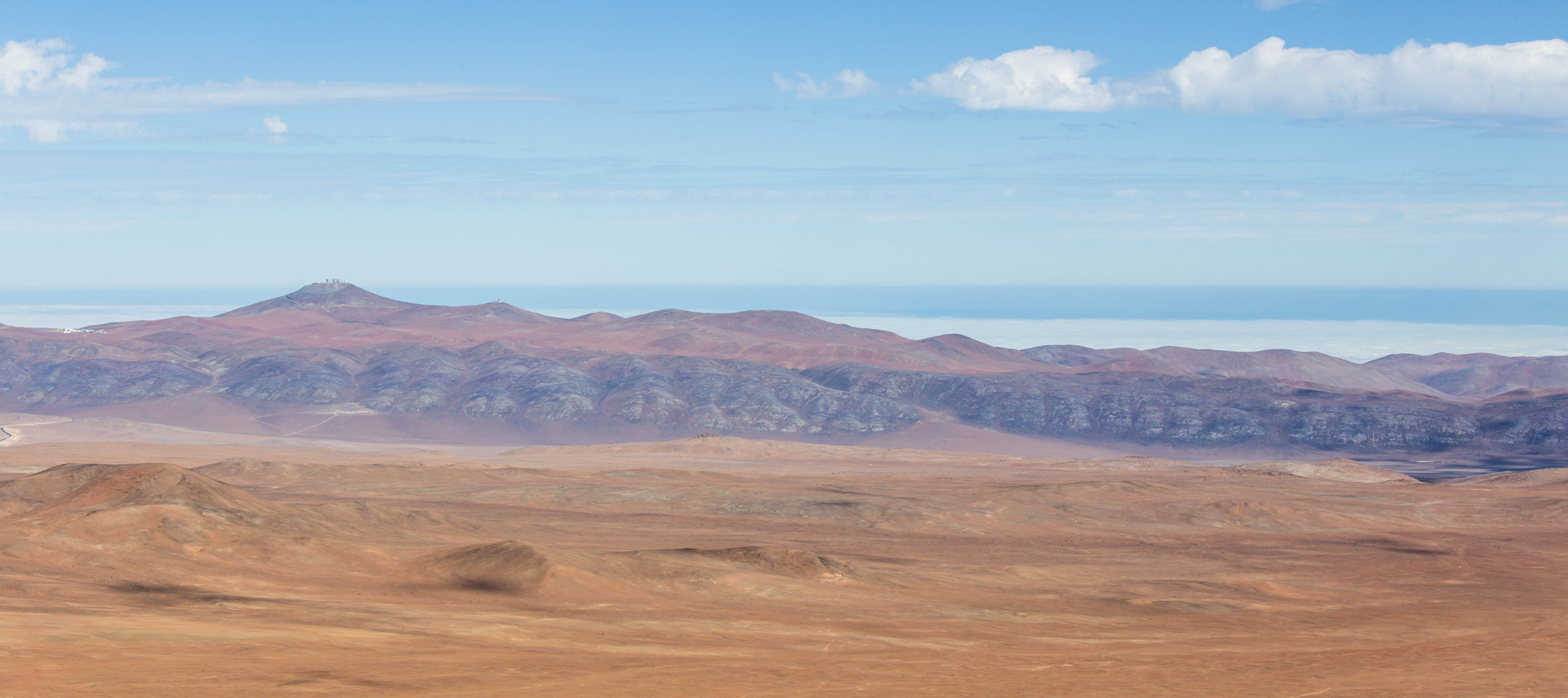 Le Cerro Paranal vu depuis le Cerro Armazones (le camp de base, la plateforme des télescopes et le télescope VISTA)